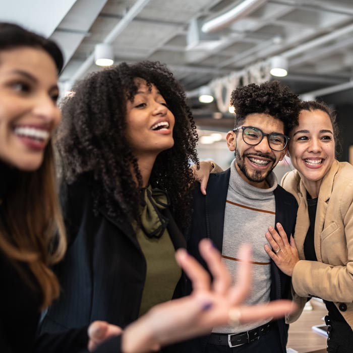 Coworkers embracing and talking at the office