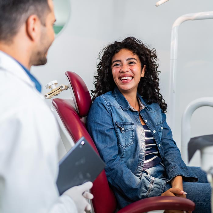 Young patient woman talking to dentist at dentist's office