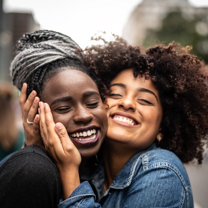 two friends smiling and hugging